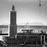 Faro e nave davanti al porto