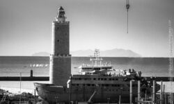 Faro e nave davanti al porto