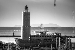 Faro e nave davanti al porto