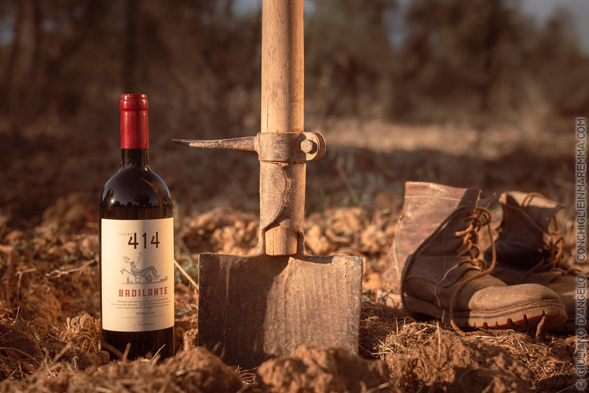 Bottiglia con badile e scarpe consumate